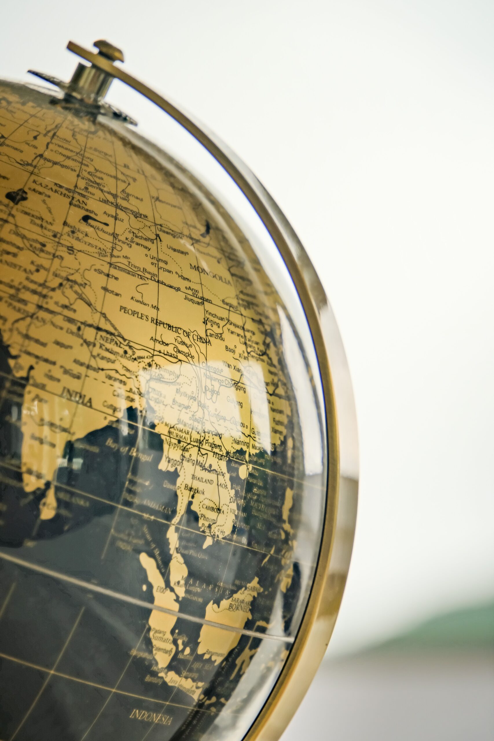 A stylish close-up of a golden-colored vintage earth globe highlighting Asia.